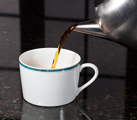 Image showing Tea poured from stainless steel teapot