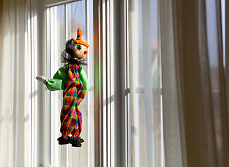 Image showing String puppet gazing outside window in sun