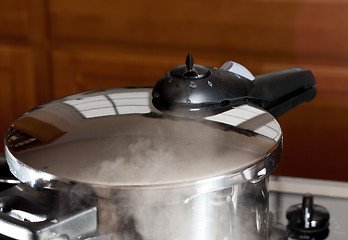 Image showing Pressure being released from cooker on hob