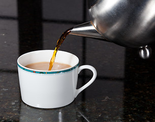 Image showing Tea poured from stainless steel teapot