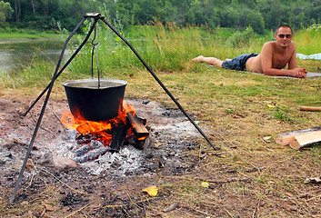 Image showing camping - kettle and lying tourist