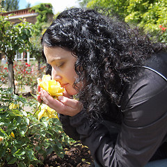 Image showing Pretty brunette smelling roses