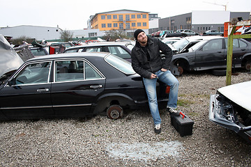 Image showing man looking at the scrap yard car parts