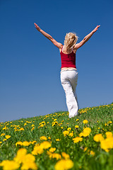 Image showing young woman in red outfit having fun on meadow