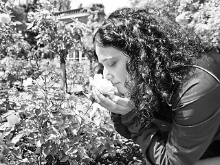 Image showing Pretty brunette smelling roses