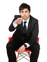 Image showing business man sit and point to you