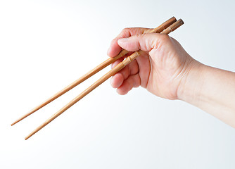 Image showing hand using chopsticks