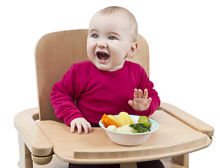 Image showing young child eating in high chair