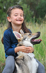 Image showing little girl and her baby wolf dog