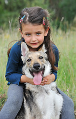 Image showing little girl and her baby wolf dog