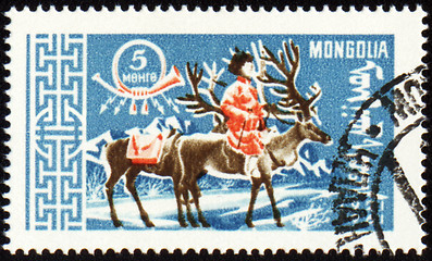 Image showing Man with reindeer in winter time on post stamp