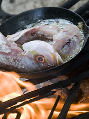 Image showing fresh fish cooking in coconut oil wood burning grill Corn Island