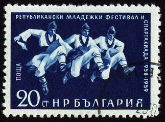 Image showing Three dancing men in Bulgarian national costumes on post stamp