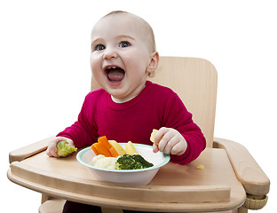 Image showing young child eating in high chair