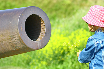 Image showing Little girl, gun and yellow flowers