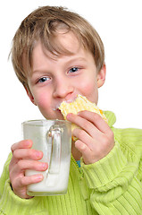 Image showing child eating cake and drinking milk