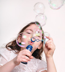 Image showing child blowing bubbles with bubble wand