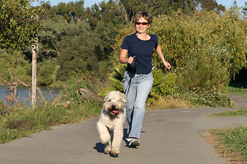 Image showing Woman running with her dog