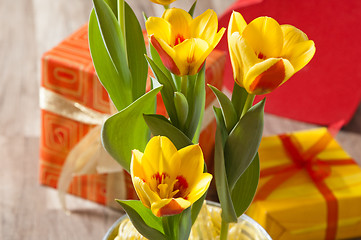 Image showing It is red yellow tulips and gift boxes, a close up