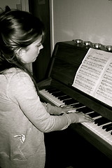 Image showing Young girl is playing classic piano