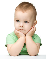 Image showing Pensive little boy support his head with hand