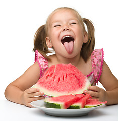 Image showing Cute little girl is gungy to eat watermelon