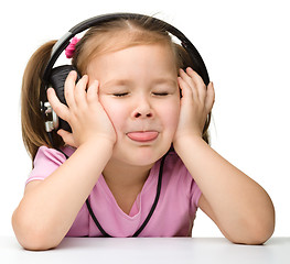 Image showing Cute little girl enjoying music using headphones