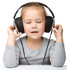 Image showing Cute girl enjoying music using headphones