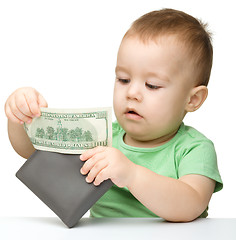 Image showing Little boy is playing with dollars