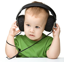 Image showing Cute little boy enjoying music using headphones