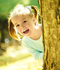 Image showing Cute little girl is playing hide and seek