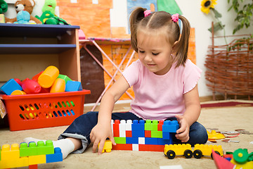 Image showing Little girl is playing with building bricks