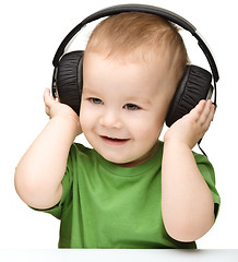 Image showing Cute boy enjoying music using headphones