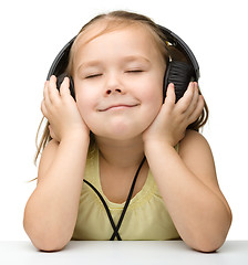 Image showing Cute little girl enjoying music using headphones