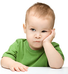 Image showing Pensive little boy support his head with hand