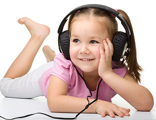 Image showing Cute little girl enjoying music using headphones