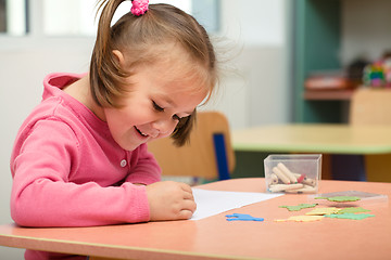 Image showing Little girl is playing with plasticine