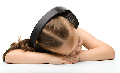 Image showing Cute little girl is sleeping in headphones