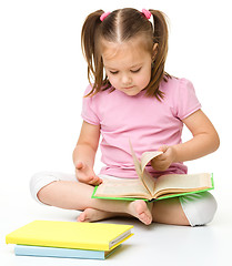 Image showing Cute little girl reads a book