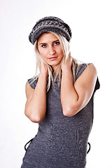 Image showing Fashionable young woman in gray sweater and cap, isolated on white background 