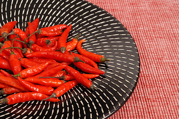 Image showing Red Thai peppers on black and white plate