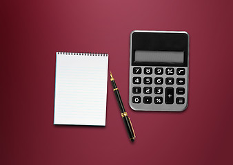 Image showing calculator, a pen and blank paper on the table 