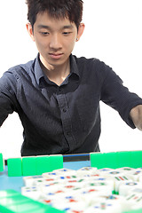 Image showing Chinese man play Mahjong, traditional China gamble. 