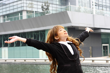 Image showing Woman relaxing with arms open enjoying her freedom and office bu