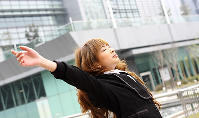 Image showing Woman relaxing with arms open enjoying her freedom and office bu