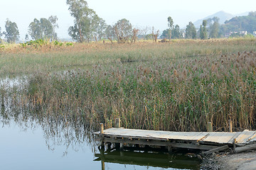 Image showing wooden pier in tranquil lake at morning 