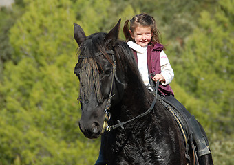 Image showing little girl and her black horse