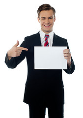 Image showing Young salesman pointing towards blank billboard