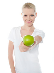 Image showing Cute teenager offering green apple