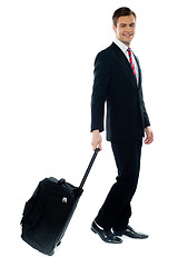 Image showing Handsome businessman dragging trolley bag